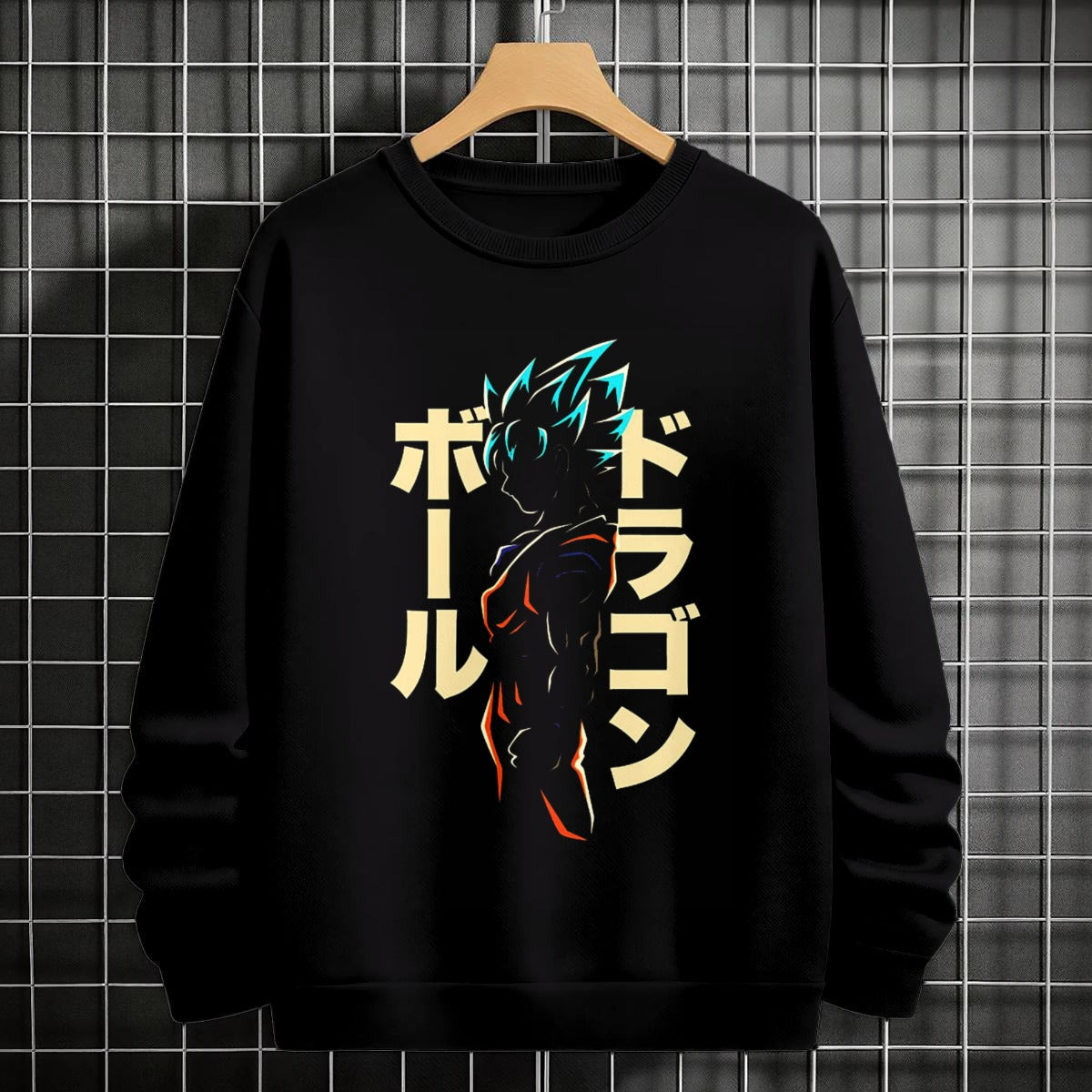 Black crewneck sweatshirt featuring Goku shadow silhouette with blue and pink neon aura and vertical Japanese text, flat lay on grey background.