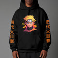 Black pullover hoodie featuring Naruto Uzumaki portrait on chest and vertical orange Japanese Kanji text on sleeves, worn by model on grey background.