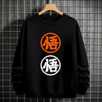 Black crewneck sweatshirt featuring two vertically stacked circular Dragon Ball Z 'Go' Kanji symbols (one orange, one white), flat lay on grey background.