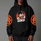 Black pullover hoodie with orange Goku silhouette on chest and vintage 1984 Dragon Ball graphics on sleeves, worn by model on grey background.