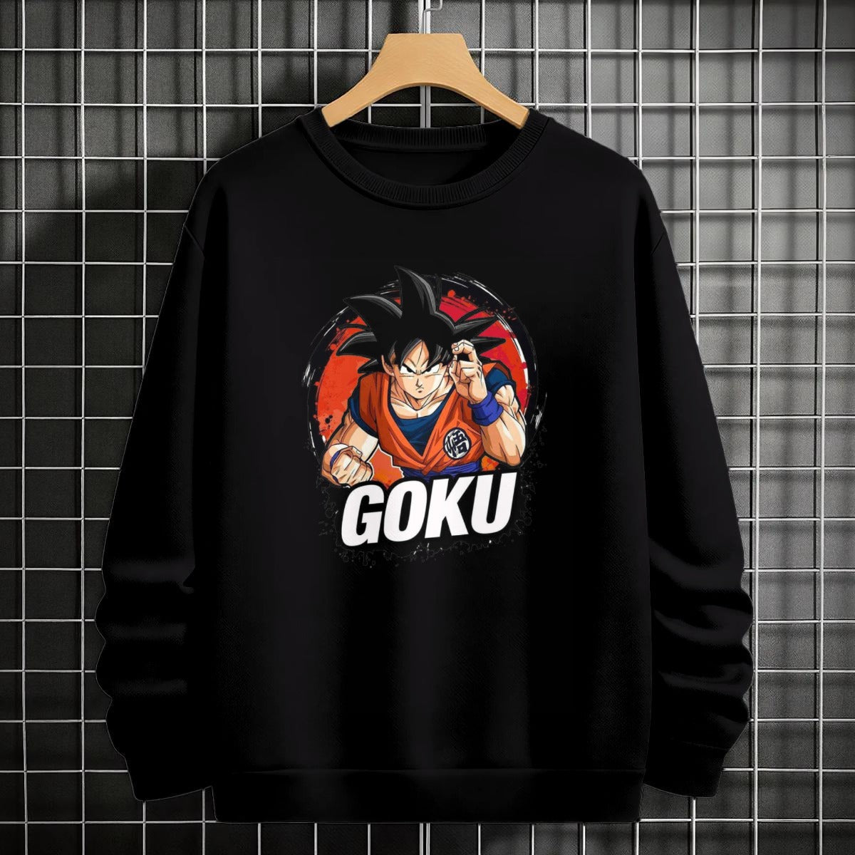 Black crewneck sweatshirt featuring Goku shadow silhouette with blue and pink neon aura and vertical Japanese text, flat lay on grey background.