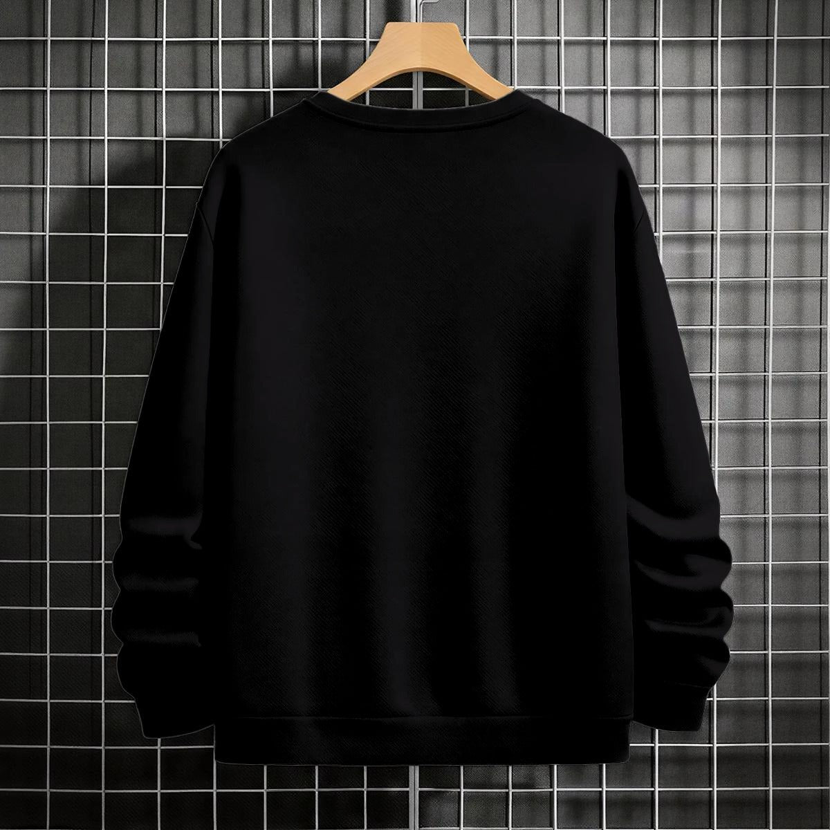 "Black crewneck sweatshirt featuring Goku shadow silhouette with blue and pink neon aura and vertical Japanese text, flat lay on grey background."