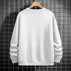 White sweatshirt on a wooden hanger against a grid-patterned wall.