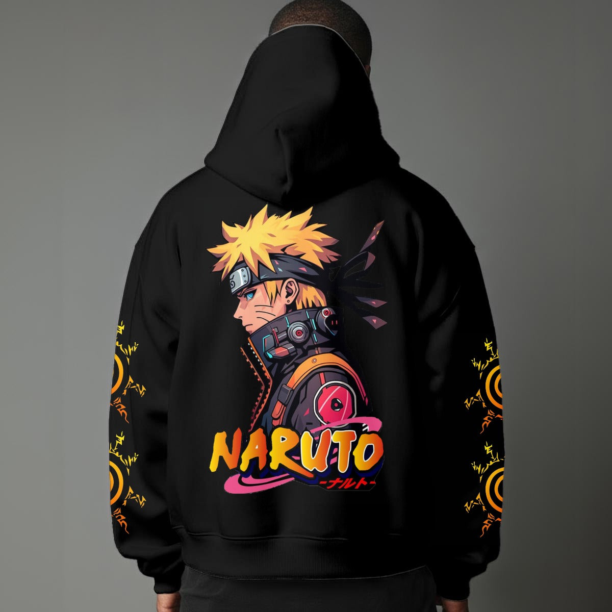 Black pullover hoodie featuring Naruto Uzumaki portrait on chest and vertical orange Japanese Kanji text on sleeves, worn by model on grey background.