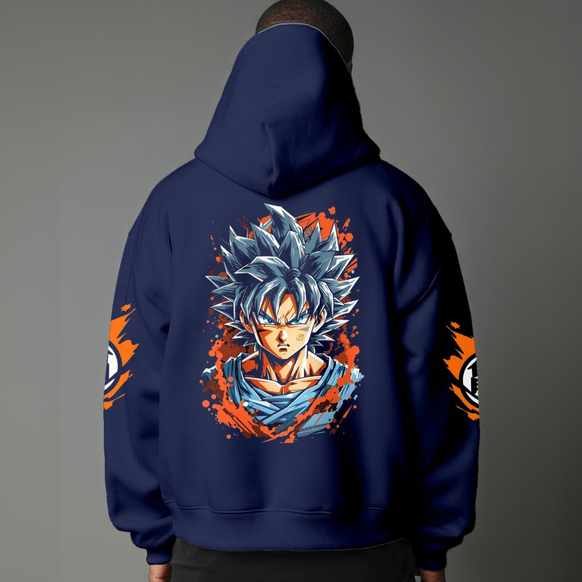 Black pullover hoodie with orange Goku silhouette on chest and vintage 1984 Dragon Ball graphics on sleeves, worn by model on grey background.