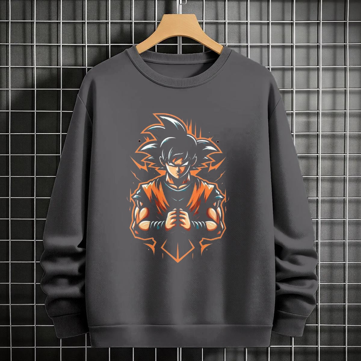 Black crewneck sweatshirt featuring Goku shadow silhouette with blue and pink neon aura and vertical Japanese text, flat lay on grey background.
