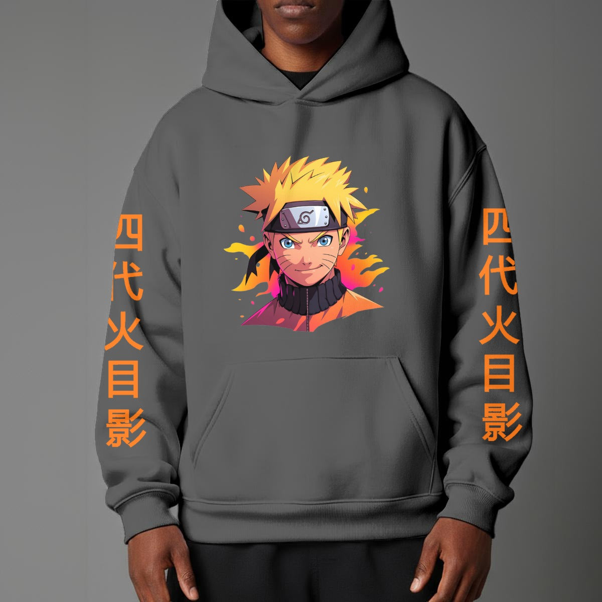 Black pullover hoodie featuring Naruto Uzumaki portrait on chest and vertical orange Japanese Kanji text on sleeves, worn by model on grey background.