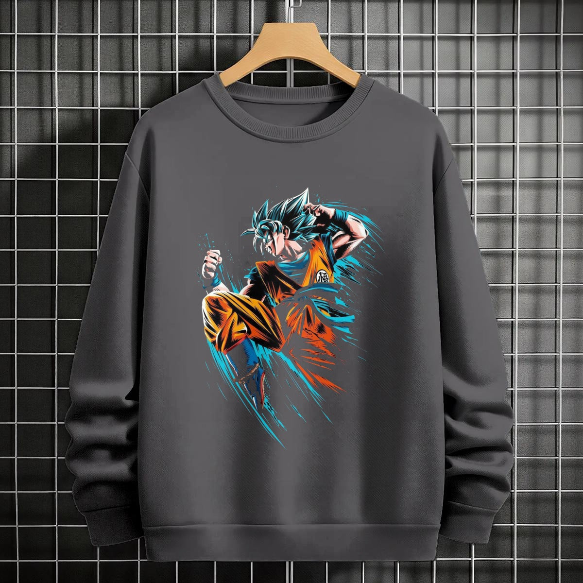 Black crewneck sweatshirt featuring Goku shadow silhouette with blue and pink neon aura and vertical Japanese text, flat lay on grey background.