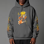 Black pullover hoodie featuring Naruto Uzumaki portrait on chest and vertical orange Japanese Kanji text on sleeves, worn by model on grey background.