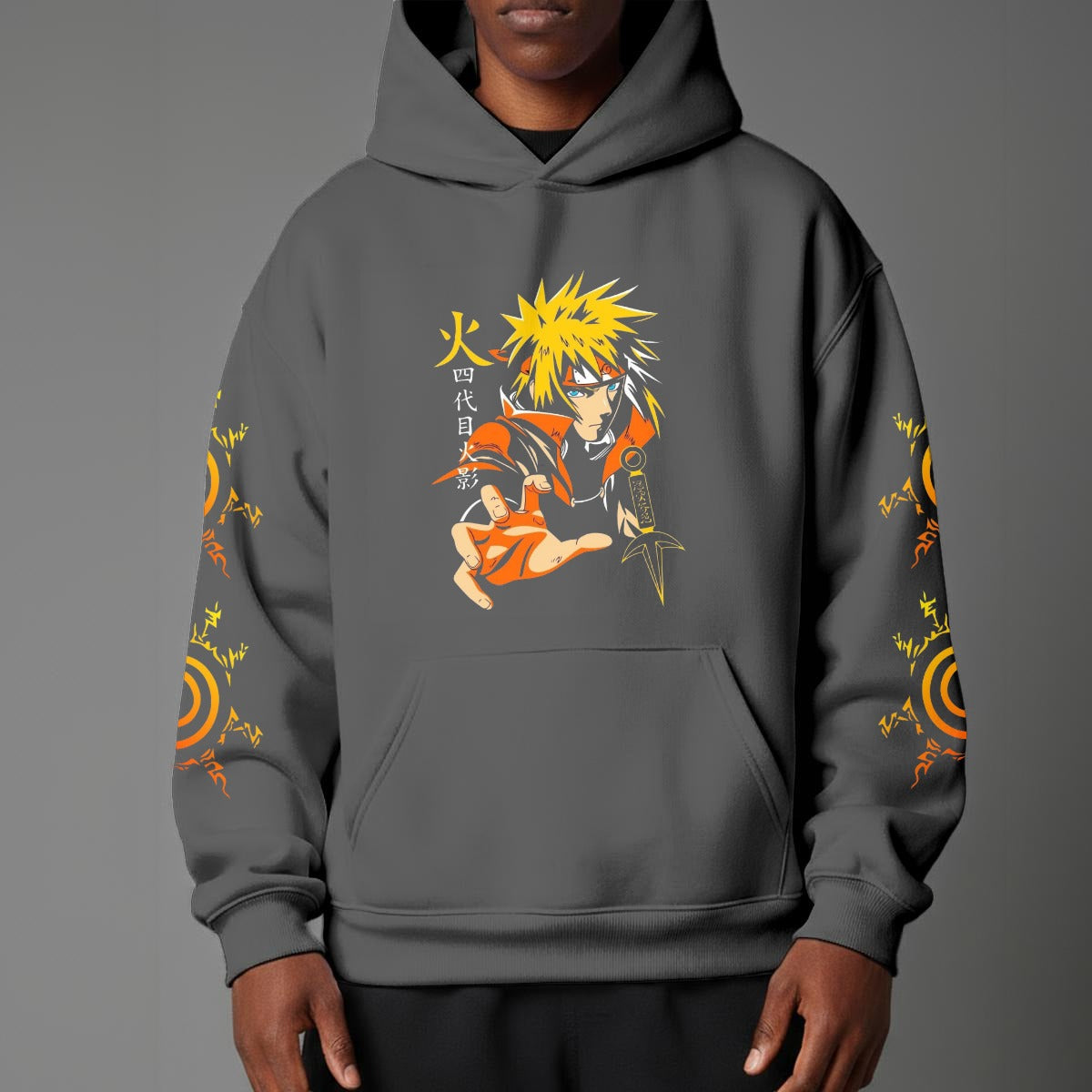 Black pullover hoodie featuring Naruto Uzumaki portrait on chest and vertical orange Japanese Kanji text on sleeves, worn by model on grey background.