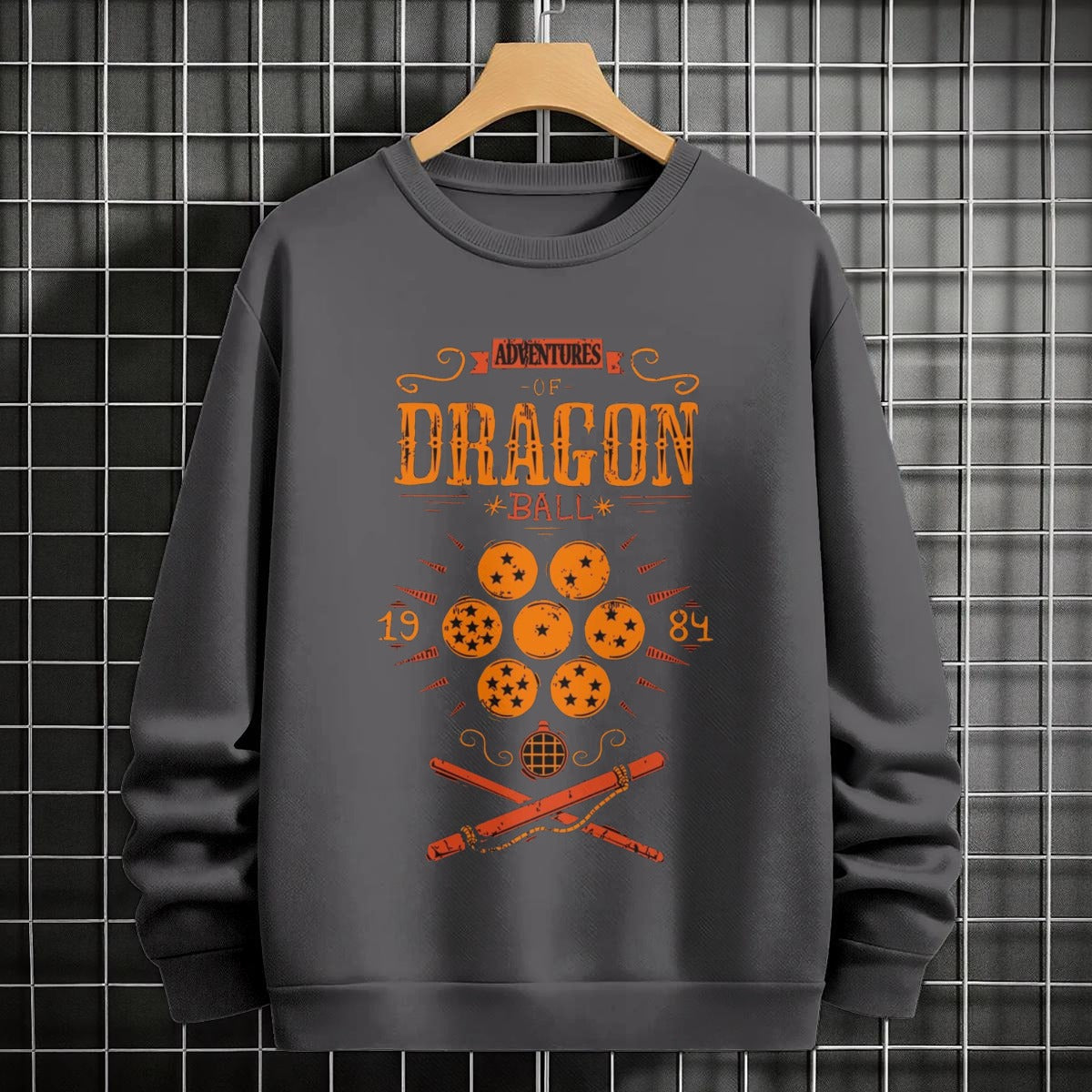 Black crewneck sweatshirt featuring Goku shadow silhouette with blue and pink neon aura and vertical Japanese text, flat lay on grey background.