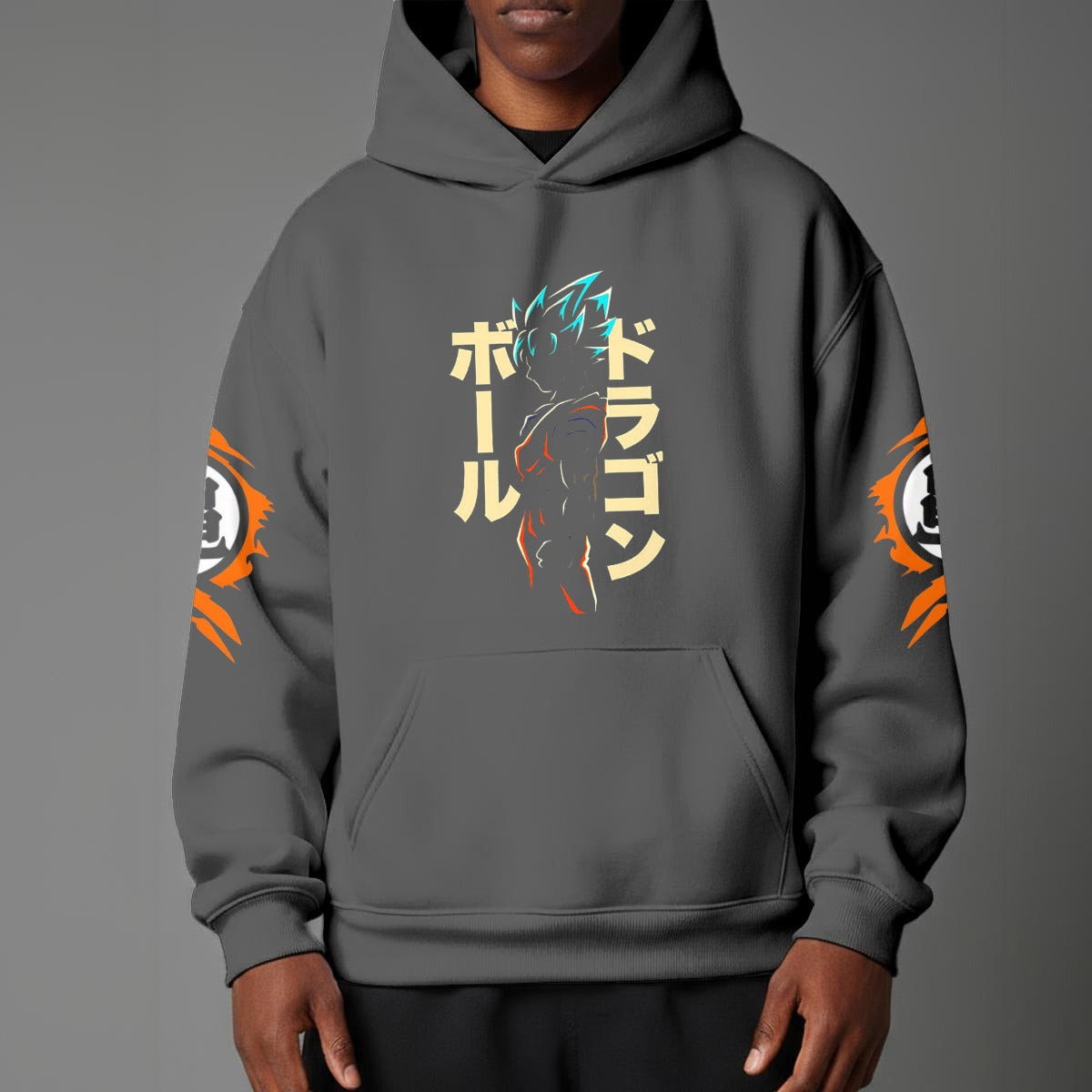 Black pullover hoodie with orange Goku silhouette on chest and vintage 1984 Dragon Ball graphics on sleeves, worn by model on grey background.