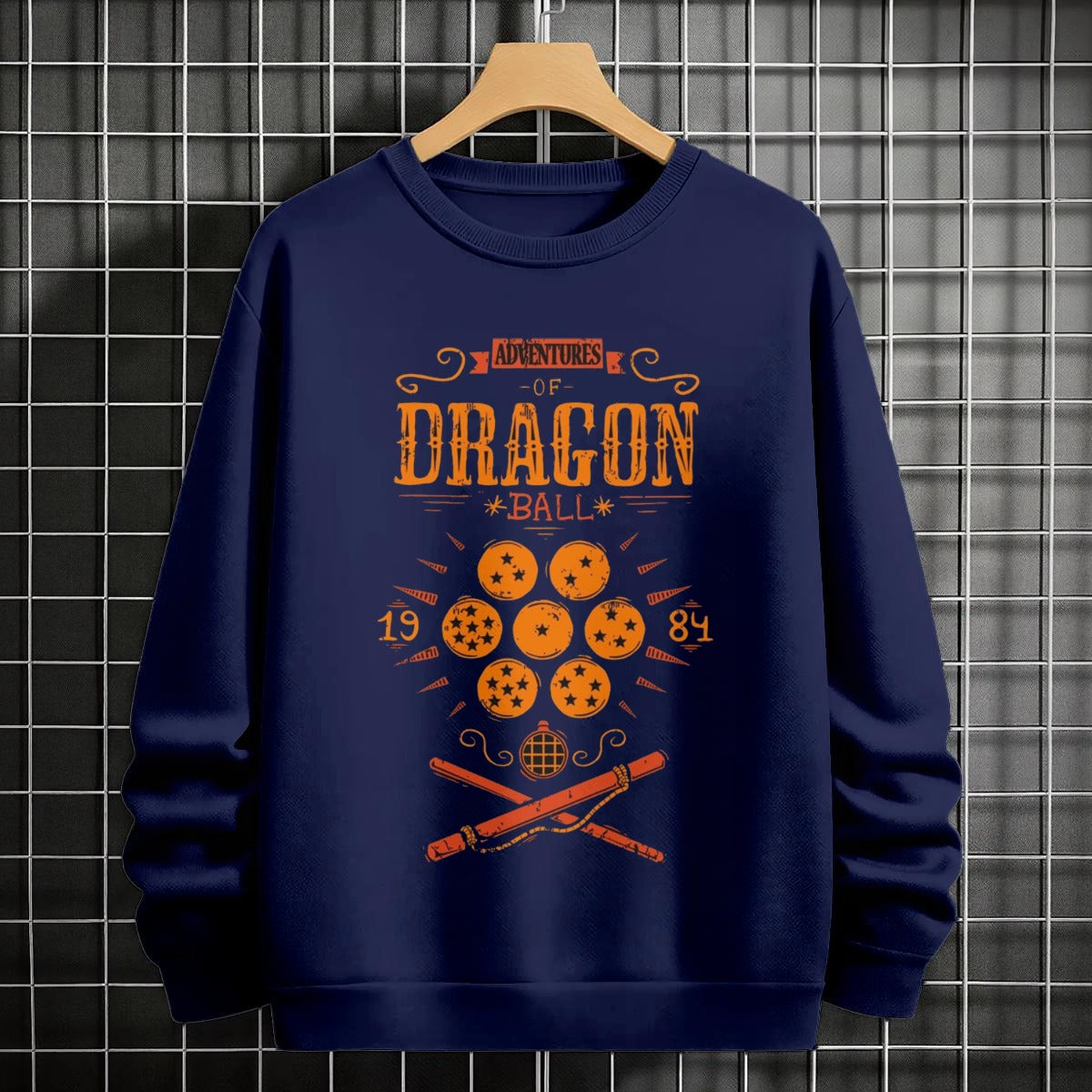 Black crewneck sweatshirt featuring Goku shadow silhouette with blue and pink neon aura and vertical Japanese text, flat lay on grey background.