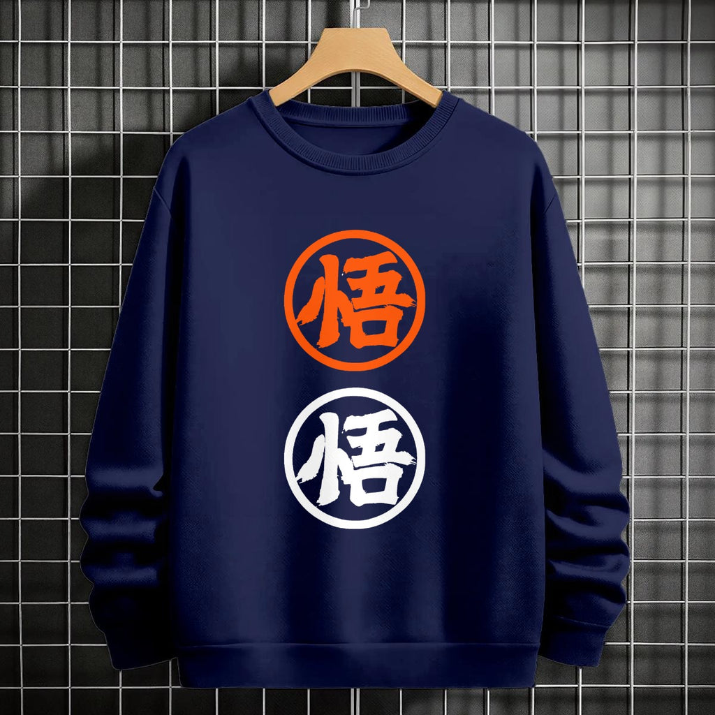 Black crewneck sweatshirt featuring two vertically stacked circular Dragon Ball Z 'Go' Kanji symbols (one orange, one white), flat lay on grey background.