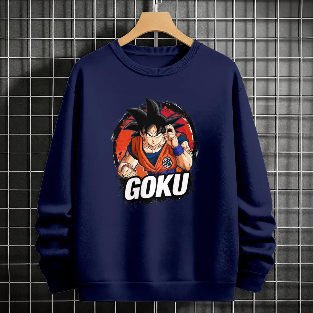Black crewneck sweatshirt featuring Goku shadow silhouette with blue and pink neon aura and vertical Japanese text, flat lay on grey background.