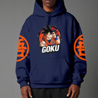 Black pullover hoodie with orange Goku silhouette on chest and vintage 1984 Dragon Ball graphics on sleeves, worn by model on grey background.