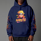 Black pullover hoodie featuring Naruto Uzumaki portrait on chest and vertical orange Japanese Kanji text on sleeves, worn by model on grey background.
