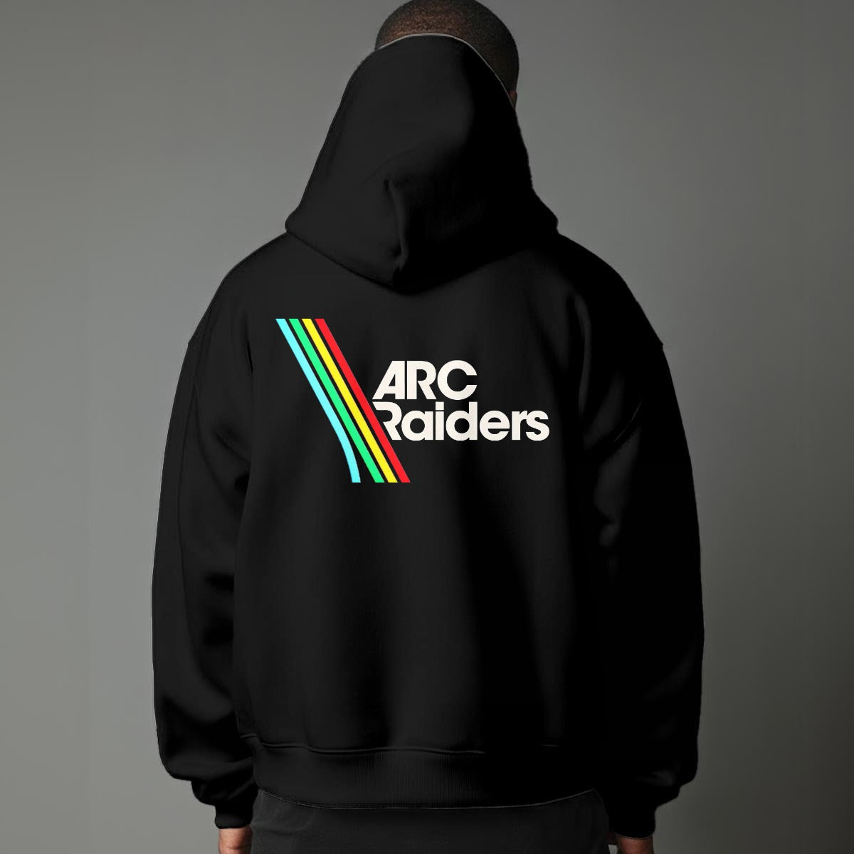 Person wearing a black hoodie with 'ARC Raiders' logo on the back against a gray background