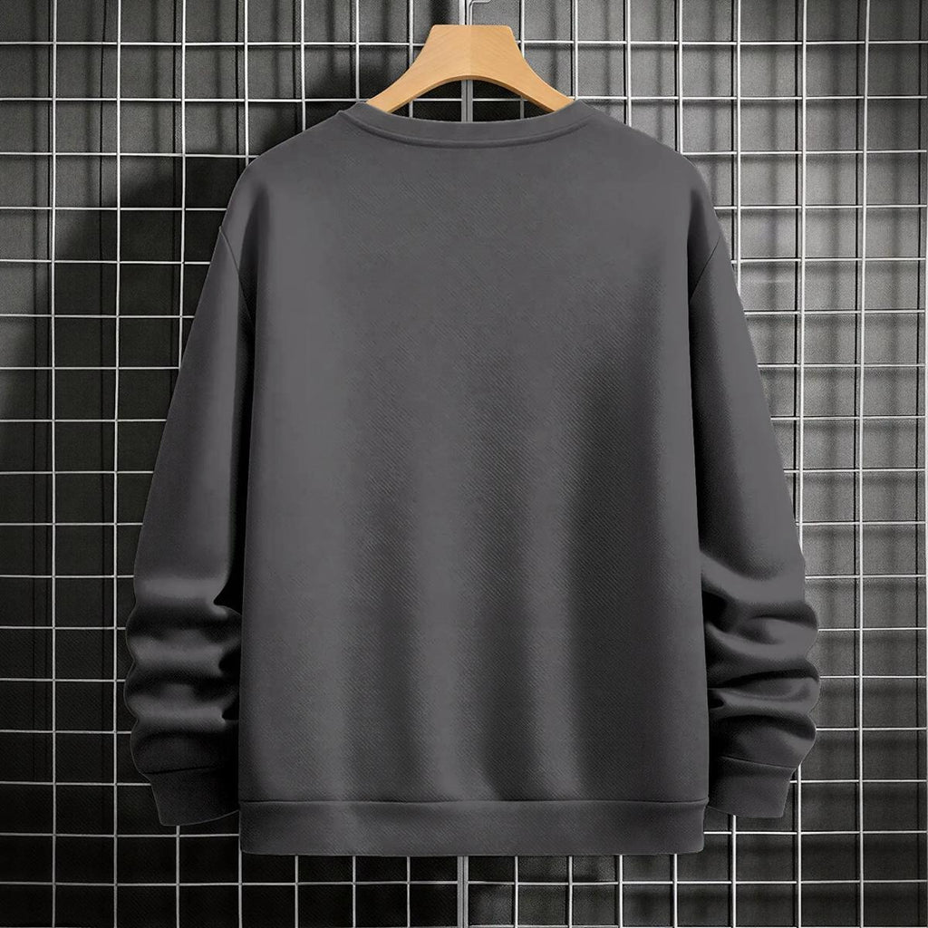 Gray sweatshirt on a wooden hanger against a black tiled wall.