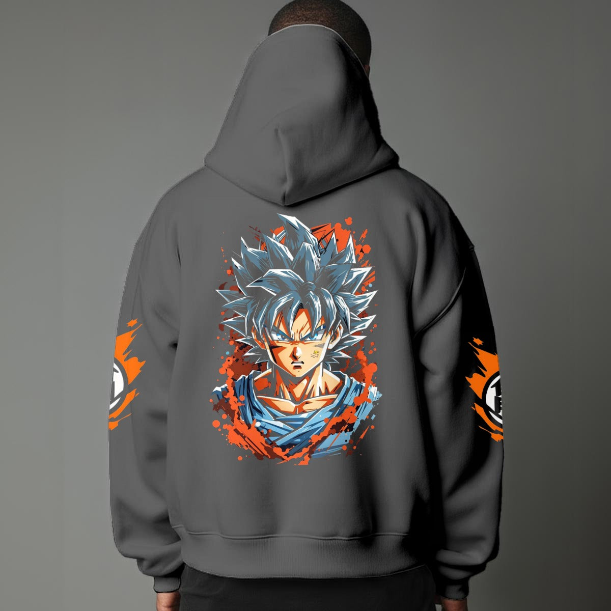 Black pullover hoodie with orange Goku silhouette on chest and vintage 1984 Dragon Ball graphics on sleeves, worn by model on grey background.