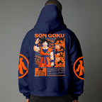 Black pullover hoodie with orange Goku silhouette on chest and vintage 1984 Dragon Ball graphics on sleeves, worn by model on grey background.