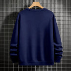 Navy blue sweatshirt on a wooden hanger against a tiled wall background